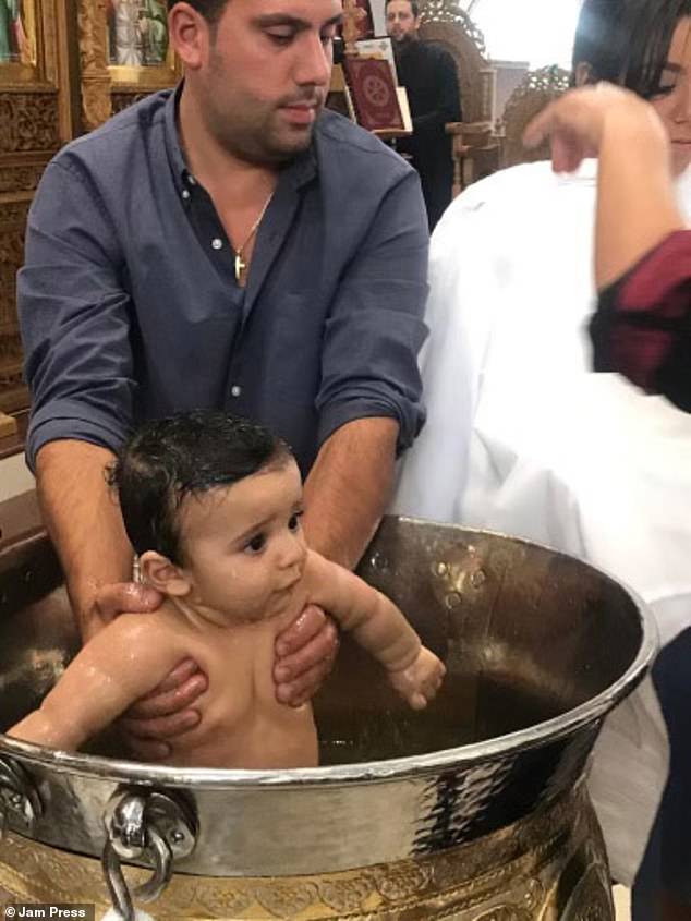 Demetri và cậu con trai 7 tháng tuổi Jonathan trong lễ rửa tội
