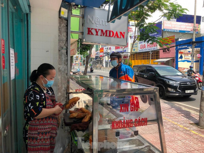 Ngày 17/9, quầy bánh mì trên đường Nguyễn Thị Thập (phường Tân Phong, quận 7) tấp nập khách và shipper chờ mua hàng. “Hôm nay là lần đầu tiên tôi ra đường, gặp ngay quán bánh mì và trà sữa nên mừng quá, tôi mua luôn 10 phần đem về nhà cho mọi người cùng thưởng thức” – anh Thành (ngụ quận 7) chia sẻ. Chỉ trong vòng nửa giờ đồng hồ, shipper liên tục đến lấy hàng. Người bán vừa chế biến, vừa gọi điện thoại “hối” người giao vì “cháy hàng” bánh mì. Mới hơn 9 giờ sáng, tủ bánh mì đã hết nhưng vẫn còn nhiều khách đến mua…