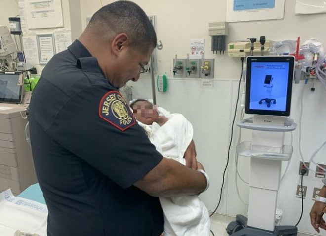 Cảnh sát Eduardo Matute bế em bé 1 tháng tuổi tại bệnh viện. Ảnh: Twitter City of Jersey City