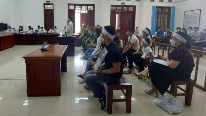 Người nhà cầm di ảnh nạn nhân đến phiên tòa sơ thẩm.