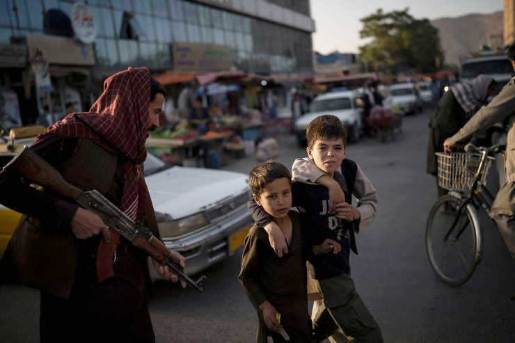 Các cậu bé Afghanistan đi qua một tay súng Taliban ở thủ đô Kabul, Afghanistan, hôm 14/9. Ảnh: AP