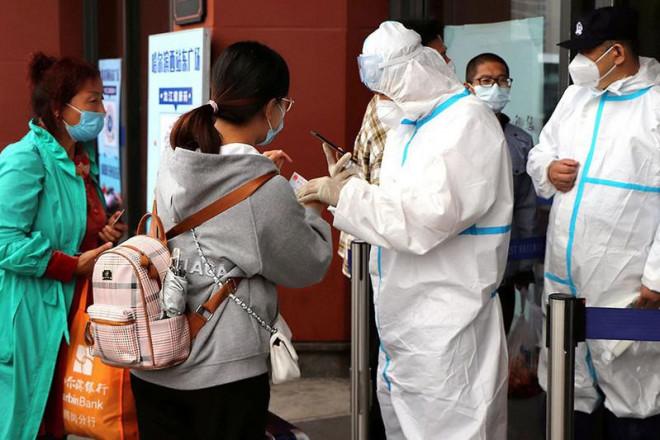 Người dân Trung Quốc ở thủ đô Bắc Kinh kiểm tra mã sức khỏe trước khi lên tàu điện hồi tháng 8. Ảnh: AP