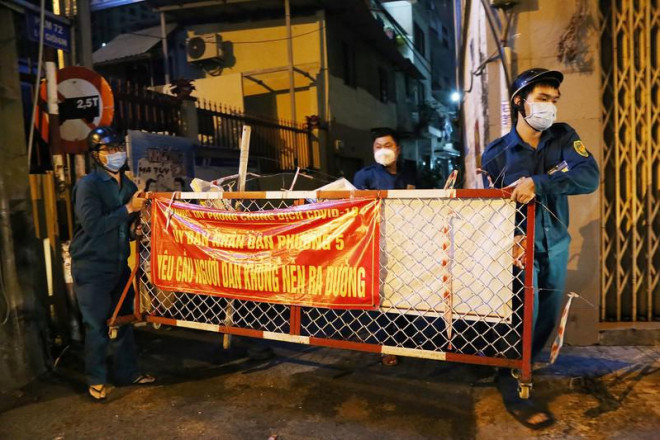 Lực lượng chức năng tháo dỡ các hàng rào ở phường 5, quận Phú Nhuận tối 27-9. Ảnh: HOÀNG GIANG