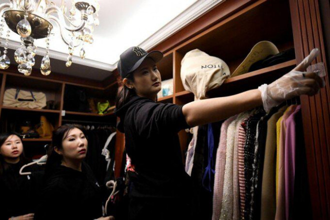 Một nhóm chuyên gia dọn dẹp sắp xếp lại tủ đồ hiệu của một khách hàng ở Bắc Kinh. Ảnh: AFP.