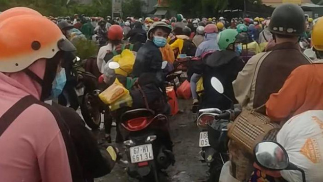 Hàng trăm người dân chạy xe máy về quê đang tụ tập tại khu vực chốt kiểm soát xã Hựu Thạnh (huyện Đức Hoà, tỉnh Long An) đêm 29 và sáng 30/9.