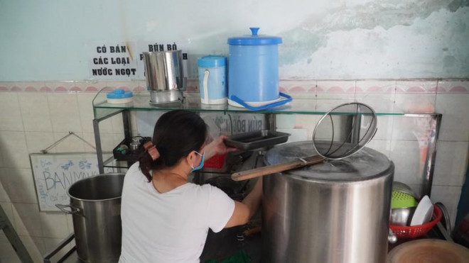 Chị Trang đang lau dọn vật dụng trong quán bún bò sau hơn 3 tháng đóng cửa