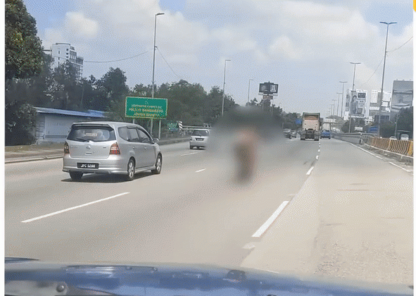 Người đàn ông chạy xe máy trên phố trong tình trạng không mặc quần áo