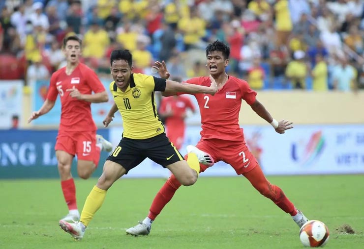 U19 Malaysia (áo vàng) và U19 Singapore thi đấu quyết tâm