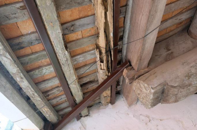 Nhiều cấu kiện gỗ bị mối mục, nứt vỡ, chính quyền địa phương phải dùng khung sắt để gia cố