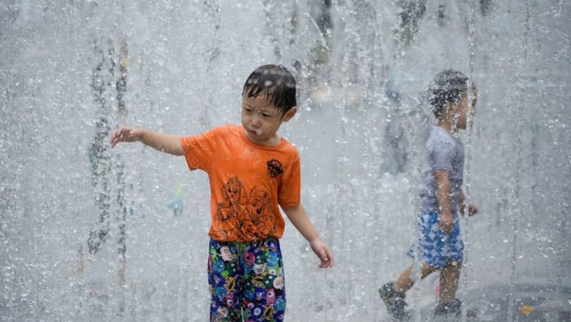 Trẻ em nô đùa bên đài phun nước ở thành phố Thượng Hải hôm 12/7. Ảnh: Reuters