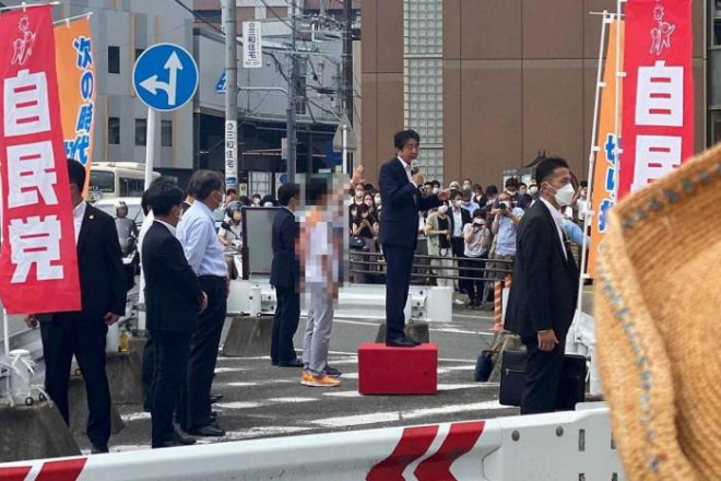 Cựu Thủ tướng Nhật Bản Abe Shinzo phát biểu trong khu vực rào chắn bảo vệ được lập nên bên ngoài ga tàu tại tỉnh Nara hôm 8/7 trước khi bị bắn. Ảnh: EPA-EFE