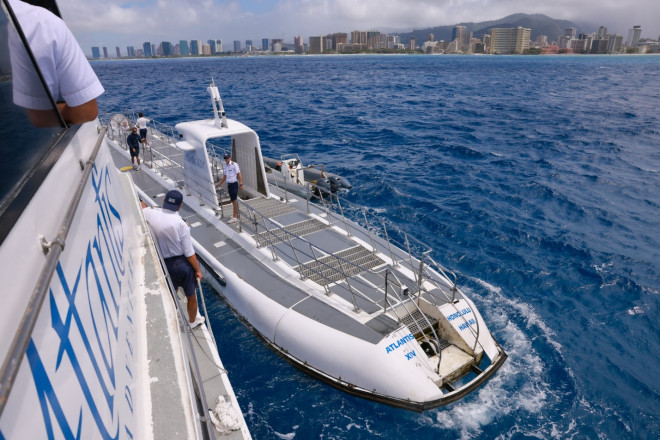 Du khách di chuyển từ tàu lớn sang tàu ngầm