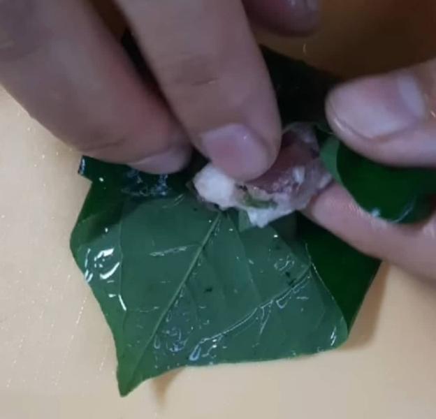 Khi gói chả, bạn dùng một thìa canh để lấy được một lượng thịt đều như nhau. Lá lốt bạn để mặt lưng lá lên trên, cho thịt vào rồi gấp 2 bên cạnh lại cho thẳng, gấp xong bạn mới bắt đầu cuộn lại như hình hướng dẫn. Cách gói này giúp chả được to đều và "vuông cành sát cạnh".