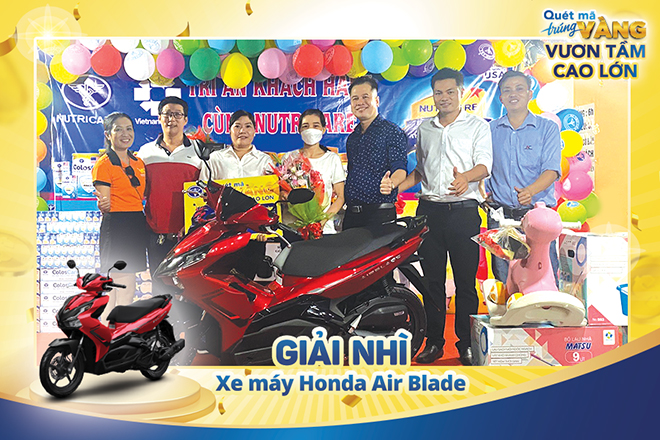 Đại diện nhãn hàng Metacare và Care 100 của Công ty Nutricare trao giải thưởng là 01 chiếc xe máy Air Blade cho chị Tô Thị Xuân (ở giữa, cầm hoa)