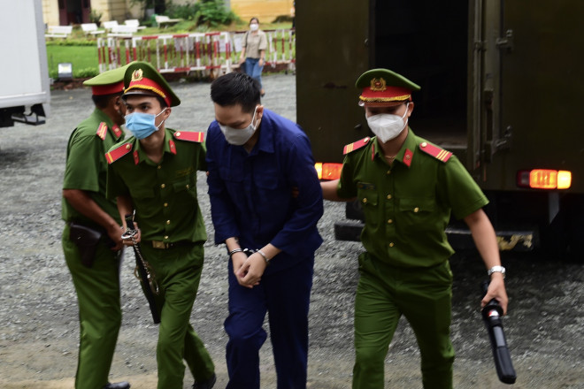 Nguyễn Kim Trung Thái được áp giải vào khu vực phòng xét xử. Ảnh: Hoàng Triều