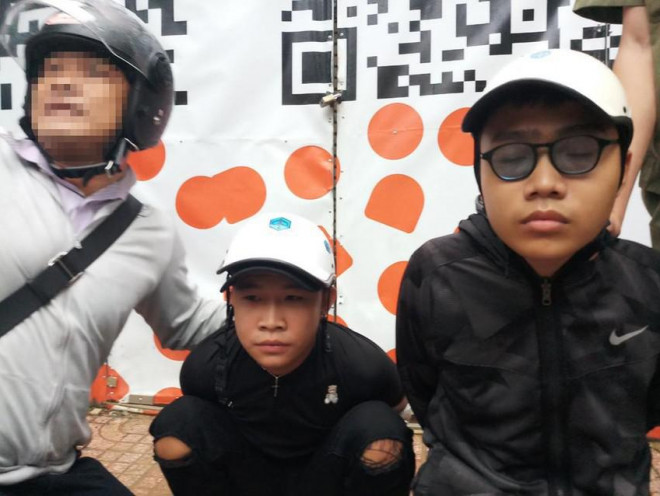 Hai thanh niên cướp giật (Quang Tiến, đeo kính, bên phải) bị hiệp sĩ và người dân khống chế. Ảnh: HSTB
