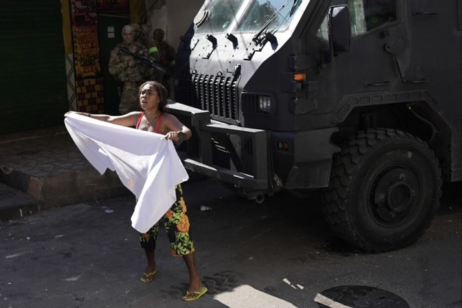 Một phụ nữ vẫy tấm vải trắng trong chiến dịch đột kích đẫm máu của cảnh sát thành phố Rio de Janeiro.