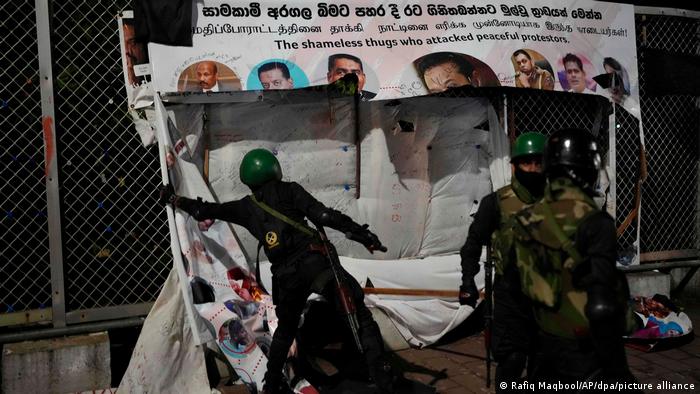 Các binh sĩ gỡ bỏ các poster của người biểu tình. Ảnh: AP