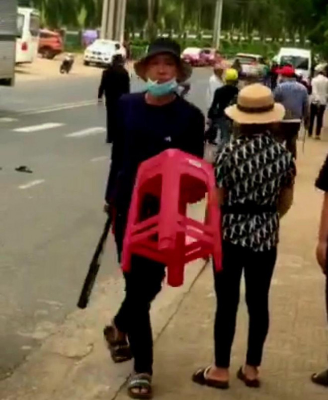 Hai nhóm thanh niên khoảng 10 người xách dao, gậy sắt rượt đuổi nhau trước khu du lịch. (Ảnh cắt từ clip)