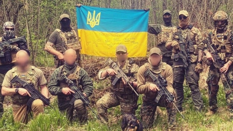 Một nhóm binh sĩ nước ngoài cầm quốc kỳ Ukraine (ảnh: RT)