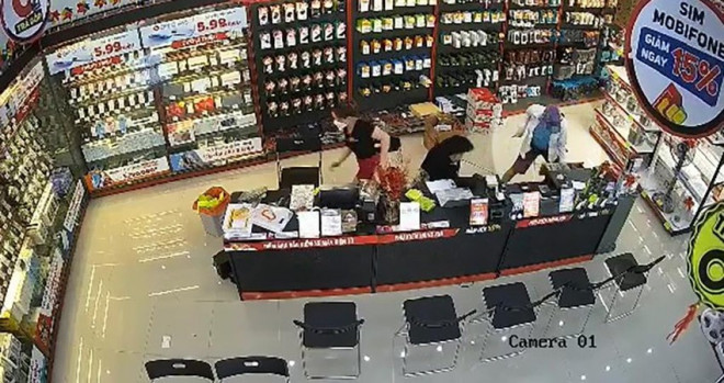 Người đàn ông cầm dao xông vào cửa hàng điện thoại cướp tài sản. Ảnh chụp từ clip