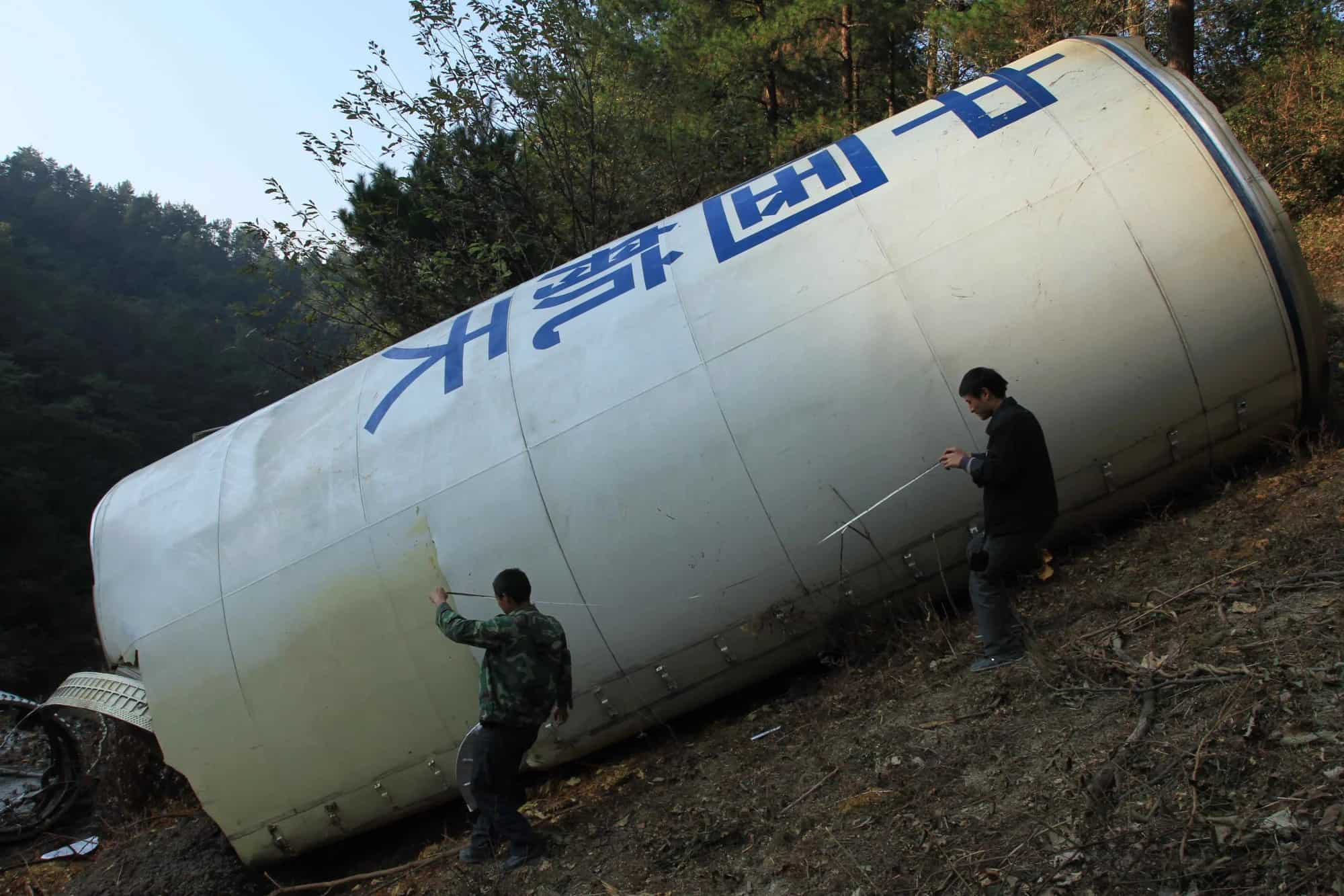 Các công nhân đo mảnh vỡ của tên lửa Long March-3C ở tỉnh Quý Châu, miền nam Trung Quốc, năm 2010.&nbsp;Ảnh: Tân Hoa xã