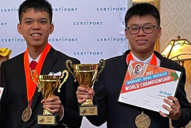 Bùi Công Minh (phải) và Nguyễn Duy Phong chụp ảnh lưu niệm với cúp vô địch cuộc thi Tin học văn phòng thế giới 2022 tại Mỹ sau khi kết quả được công bố, rạng sáng 28/7 giờ Việt Nam