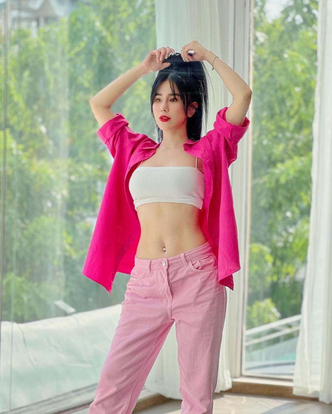 Vốn là dancer, Diệp Lâm Anh cũng rất ưa chuộng phong cách thể thao, năng động. Ở đây, cô chọn mặc croptop 2 dây khoác ngoài áo sơ mi và phối cùng quần cạp trễ.