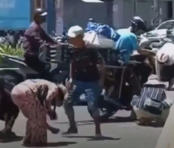 Nhiều người bán hàng rong, bán vé số lao ra đường nhặt vàng khi đối tượng cướp tiệm vàng ở chợ Đông Ba ném vàng ra đường. (Ảnh cắt từ clip).