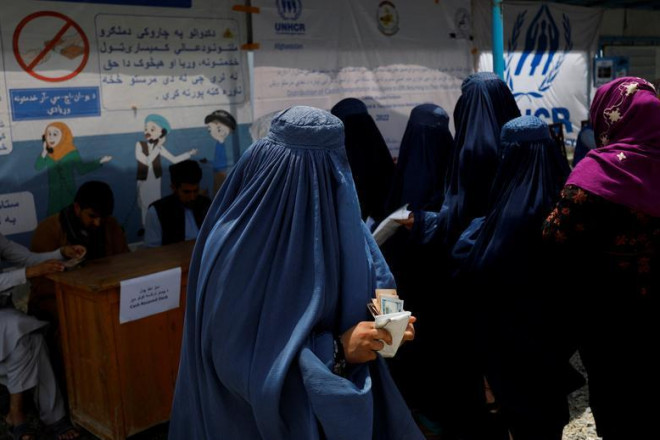 Một phụ nữ Afghanistan nhận tiền hỗ
trợ từ 1 tổ chức từ thiện