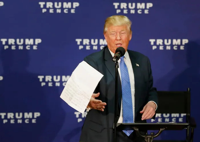 Ông Trump vứt một tờ giấy chứa số liệu thăm dò ý kiến người dân trong sự kiện vận động tranh cử ngày 6/10/2016 tại New Hampshire, Mỹ (ảnh: AP)