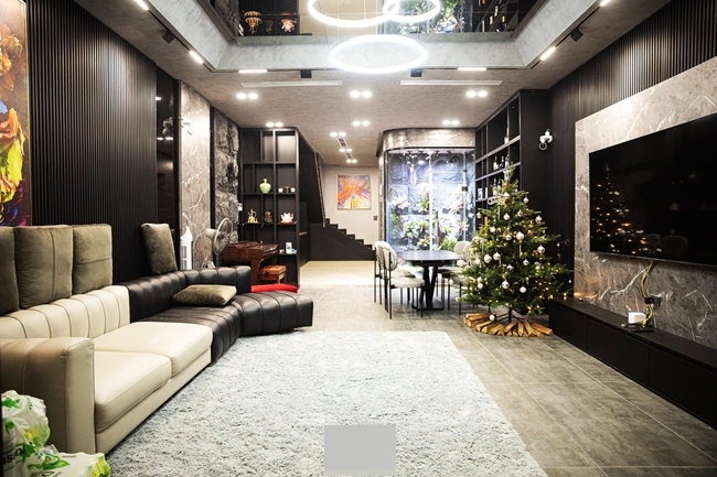 Phòng khách với gam màu trầm kết hợp cùng nội
thất tối giản, không rườm rà toát lên vẻ sang trọng nhưng không kém
phần ấm áp. Cây thông Giáng sinh trang trí lộng lẫy giữa phòng trở
thành điểm nhấn, đem lại bầu không khí tươi vui và năng lượng tích
cực.