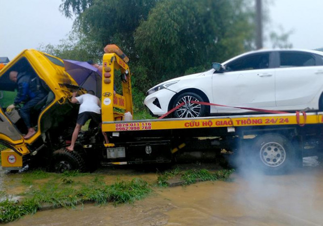 Chiếc xe ô tô bị nước lũ cuốn trôi đã được trục vớt và di chuyển đến vị trí an toàn.