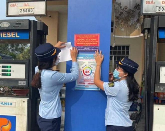 Lực lượng QLTT tỉnh An Giang thông tin về đường dây nóng tại các cửa hàng xăng dầu. ẢNH: Cục QLTT tỉnh An Giang