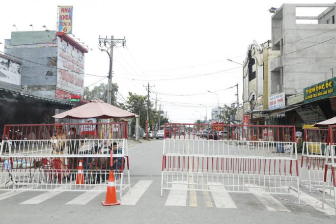 Đoạn đường vào quán karaoke An Phú được phong tỏa nghiêm ngặt để cơ quan điều tra khám nghiệm hiện trường. Ảnh: LÊ ÁNH