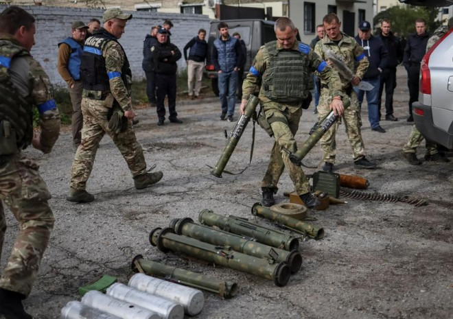 Lính Ukraine phân loại các loại bom, mìn chưa nổ ở thị trấn Zolochiv, Kharkiv. Ảnh: NYT