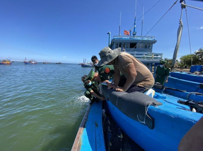 Lực lượng chức năng kiểm tra vết đạn găm trên ca nô tàu cá