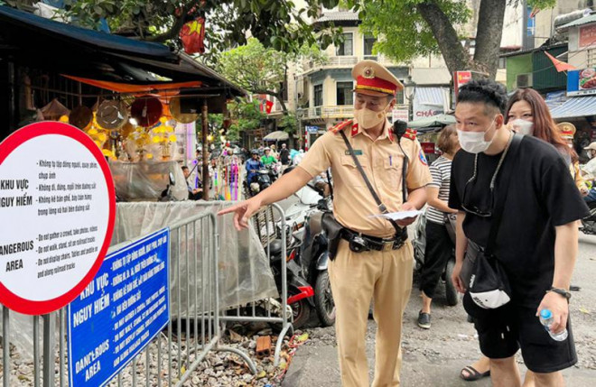 Cán bộ CSGT Hà Nội phát tờ rơi song ngữ tuyên truyền, nhắc nhở an toàn đến người dân và du khách