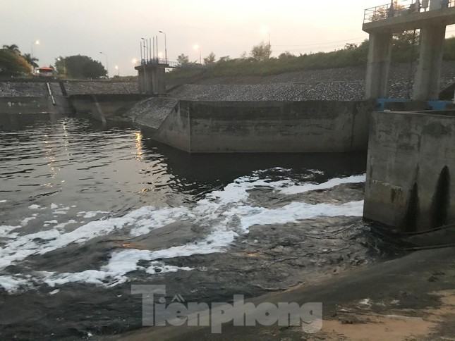 Nước chảy từ phía nội đô qua kênh dẫn nước Yên Sở, chảy ra sông Hồng. Trên dòng nước xuất hiện bọt trắng xoá. Ảnh: Trường Phong
