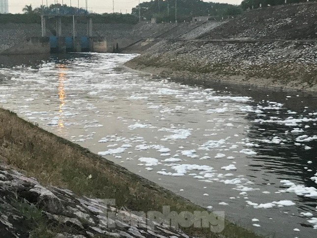 Bọt trắng trôi theo dòng nước từ phía nội đô Hà Nội chảy ra kênh dẫn nước Yên Sở. Ảnh: Trường Phong
