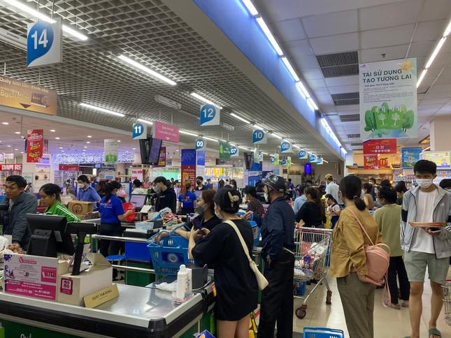 Khách hàng tấp nập, chờ thanh toán trong siêu thị. Siêu thị vẫn đang bán hàng bình ổn giá và sẽ yêu cầu kho cung ứng nguồn hàng dồi dào hơn để phục vụ người dân trong những ngày mưa bão sắp tới.