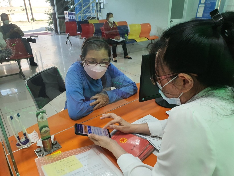 Nhân viên EVNHCMC hướng dẫn khách hàng sử dụng App EVNHCMC CSKH - Ảnh: EVNHCMC.