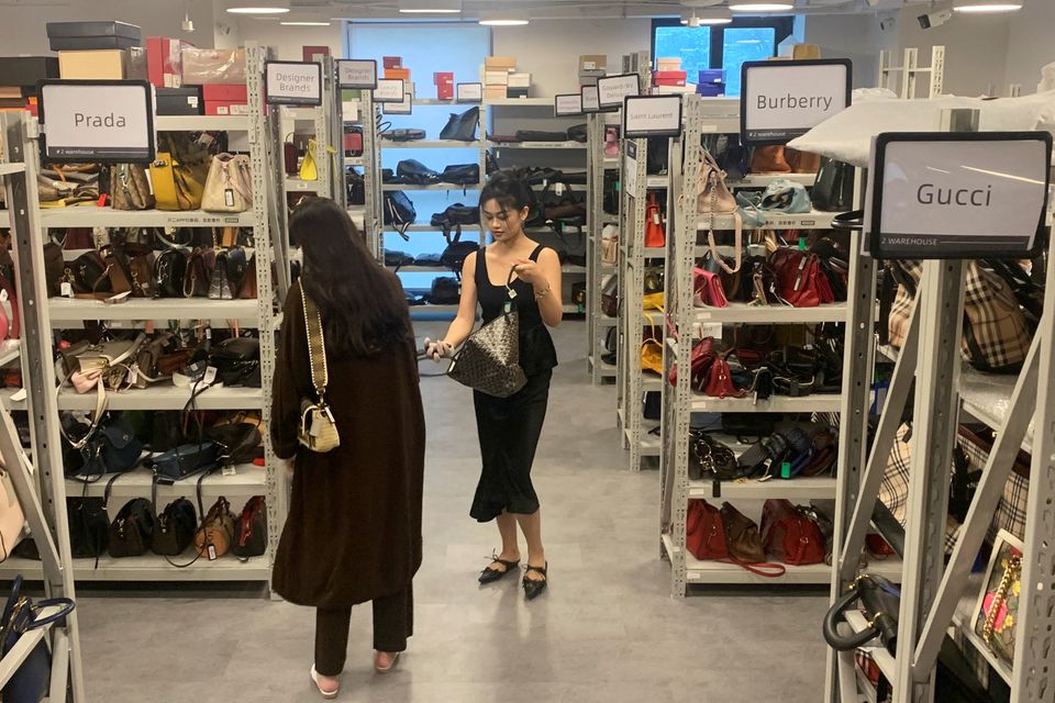 Khách hàng lựa chọn các túi xách được trưng bày tại một cửa hàng đồ xa xỉ đã qua sử dụng của công ty ZZER tại thành phố Thượng Hải, Trung Quốc, ngày 9/9.&nbsp;Ảnh: Reuters