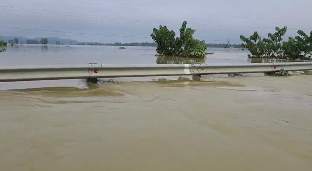 Nước ngập sâu, gần ngập hết rào chắn đường quốc lộ 1A.