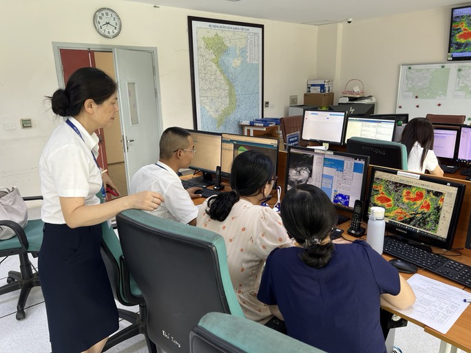Bà Nguyễn Lan Oanh - Phó Trưởng phòng Quản lý hoạt động bay - Cục Hàng không Việt Nam cùng kíp trực Trung tâm Cảnh báo thời tiết - Trung tâm khí tượng hàng không theo dõi diễn biến của Bão số 1 ngày 17-7.