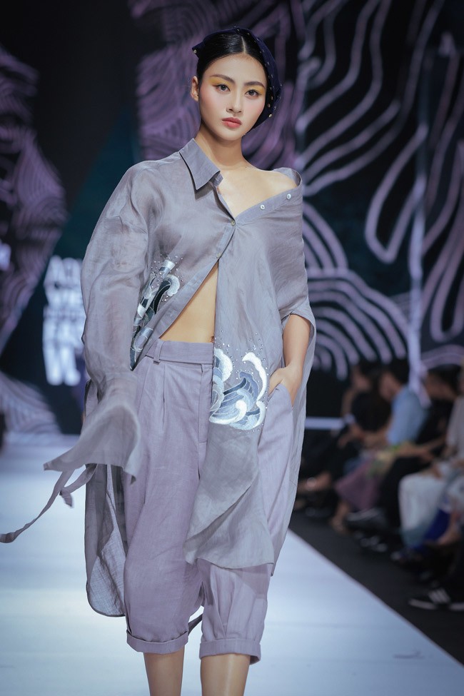 Vũ Việt Hà được thỏa sức phát triển với hai cách xử lý sợi gai: gai xuyên thấu và denim. Việc thể hiện chúng trên cùng một chiếc áo tạo ra sự tương phản rõ rệt, kích thích thị giác tối đa.&nbsp;Trên "dòng chảy" của “Nước đầu nguồn", trang phục được phát triển bằng những đường cắt cúp tự do, phóng khoáng, tạo thành nhịp điệu xuyên suốt với tông màu trắng, xám và xanh denim. Hình dáng các thiết kế đều được phát triển từ hình oval, phom freesize, tay và thân rộng, kết hợp nhịp nhàng cùng quần ống túm.