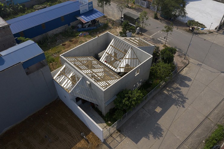 Vách bê tông lớn với kích thước 12x12x7m là yếu tố định hình về thị giác cũng như phân chia chức năng giữa khu vực công cộng có quán cafe ở bên ngoài và khu vực riêng tư dùng để sinh hoạt và ở bên trong.
