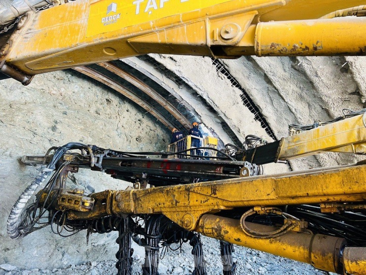 Sau khi khoan lớp mặt, nhà thầu sử dụng giá đỡ để gia cố nóc hầm và tiến hành khoan sâu vào bên trong. Sau mỗi đợt khoan sẽ phun bê tông tươi để gia cố và tăng độ bền cho công trình, ngăn không cho các khối đá biến dạng.