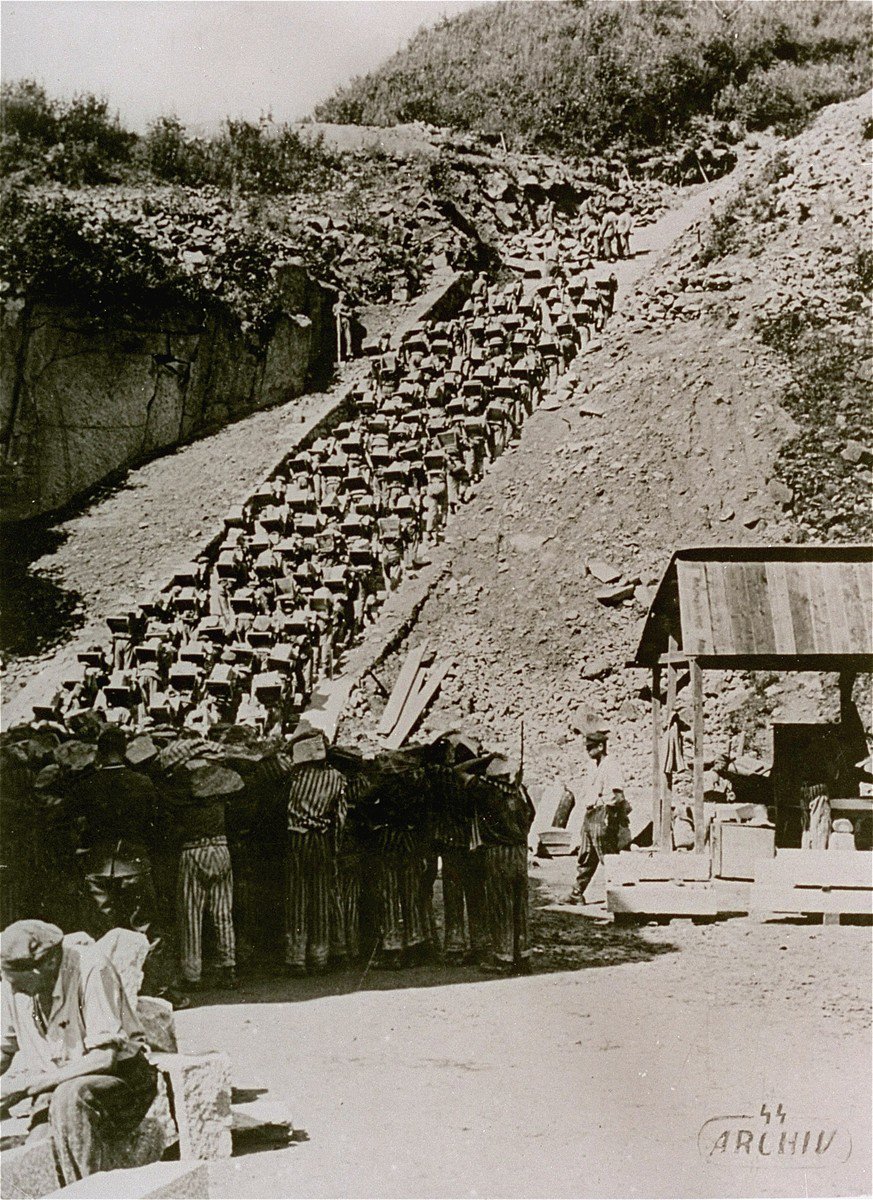 Các tù nhân vác đá nặng đi trên "Bậc thang tử thần" năm 1942. Ảnh: Archiv der KZ