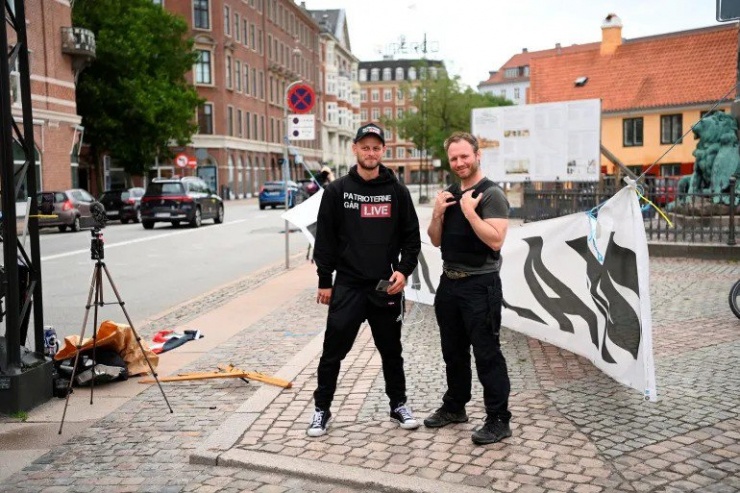 Hai người biểu tình tham gia đốt kinh Qur'an trước Đại sứ quán Iraq tại Đan Mạch. Ảnh: REUTERS